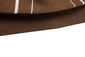 Détail du polo en maille marron café montrant l'ourlet côtelé et les rayures horizontales