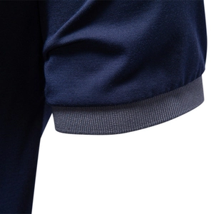 Detail of dark blue polo shirt with textured jacquard knit and grey ribbed sleeve cuff