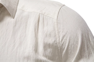 Close-up of shoulder stitching and linen fabric texture on a men's off-white business shirt