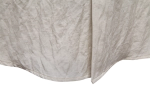 Detailed macro view of beige cotton linen fabric showing natural texture and hem stitching