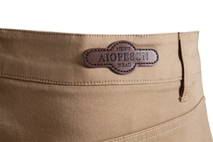 Detailed macro view of khaki cotton twill pants waist with embossed brown leather label