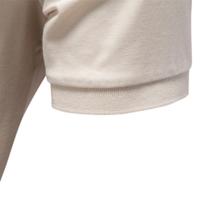 Close-up of beige Tencel polo shirt showing breathable pique fabric and ribbed cuffs