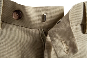Detailed macro view of khaki lyocell cotton shorts with resin button and metal hook closure