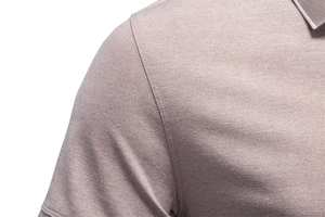 Close-up of pink pique knit polo shirt showing shoulder seam and striped collar detail