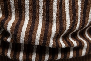 Macro shot of vertical brown and white striped texture on knitted short sleeve polo shirt