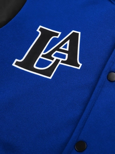 Detail of LA embroidery and matte metal buttons on blue knit baseball jacket