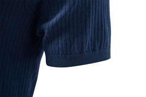 Gros plan du poignet en maille côtelée bleu marine montrant la texture et les coutures