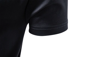 Détail de la double couture sur le poignet d'un t-shirt noir en coton ammoniaqué liquide