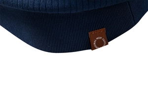 Détail macro de la maille polo bleu marine avec étiquette en cuir marron au bord
