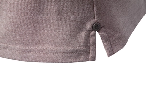 Macro detail of men's polo shirt hem with double stitching and metal side slit accent