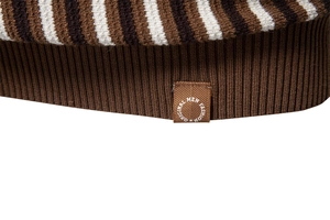 Detailed close-up of retro striped knit polo hem with ribbed cuff and fashion brand label