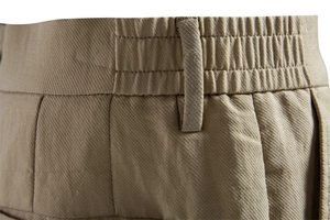 Detail of khaki lyocell cotton shorts featuring elastic waistband and twill texture