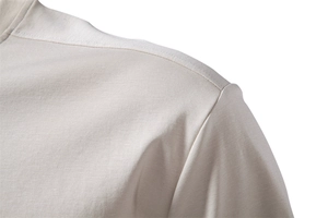 Vue macro détaillée des coutures nettes sur l'épaule de ce t-shirt en coton beige premium