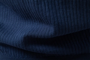 Vue macro du tissu en maille côtelée bleu foncé montrant la texture et le tissage doux