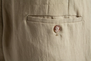 Detailed macro view of khaki lyocell cotton shorts featuring a twill texture and marble button