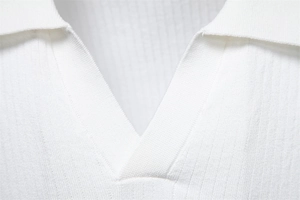 Détail d'un polo blanc en maille avec col en V et texture à rayures verticales