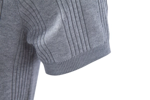 Détail de la manche du polo en maille grise avec texture côtelée et poignet resserré