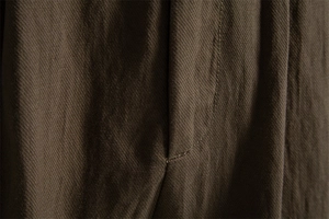 Macro detail of high-quality stitching on olive green lyocell cotton business shorts fabric