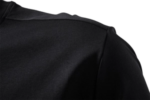 Détail de la couture d'épaule et texture du tissu d'un t-shirt noir en coton de qualité
