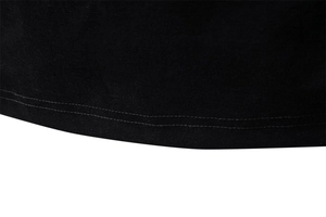 Vue macro de la double couture et texture tricotée fine sur l'ourlet du T-shirt noir