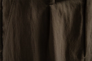 Detailed macro view of brown Lyocell cotton fabric texture and reinforced pocket stitching