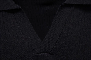 Gros plan détaillé du col côtelé et de l'encolure en V d'un polo noir en maille pour homme