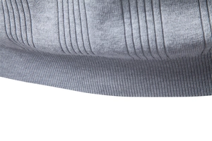 Détail du polo en maille de soie glacée grise montrant l'ourlet côtelé et la texture