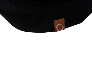 Gros plan sur la maille côtelée noire avec un écusson en cuir marron pour homme