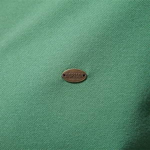 Polo pour hommes en tissu piqué vert avec un badge logo en métal bronze détaillé