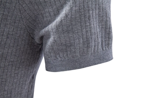 Détail de polo en maille grise montrant le revers de manche côtelé et la couture précise