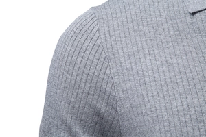 Détail du polo en maille côtelée grise montrant la couture d'épaule et la texture