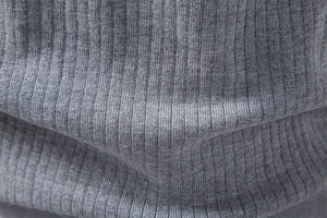 Détail macro du tissu en maille grise douce avec texture côtelée verticale sur polo chic