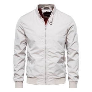 Dettaglio giacca beige uomo con collo alto, fodera in rete rossa e tasche con cerniera