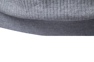 Vue macro montrant la texture en maille côtelée grise sur l'ourlet d'un polo pour homme