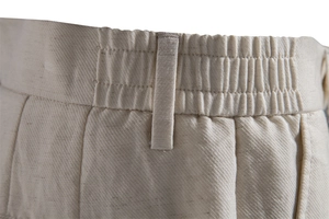 Detail of men's beige shorts showing elastic waistband and premium twill fabric texture