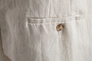 Detail of lyocell cotton blend shorts featuring twill fabric and a brown resin button