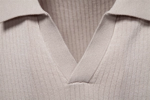 Détail du col d'un polo en maille avec texture côtelée et finitions de couture précises