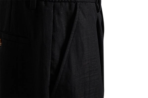 Macro detail of black twill fabric texture with pleats and side pockets on men's shorts