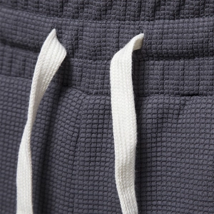 Men's dark gray waffle knit shorts featuring elastic waistband and contrast drawstring