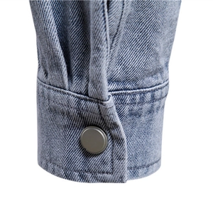 Close-up of washed blue denim jacket cuff with durable metal button and fine stitching