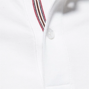 Primer plano del cuello de polo de algodón blanco con cinta a rayas y un botón blanco