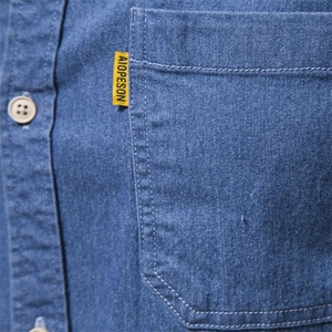 Men's blue denim long sleeve shirt featuring a front pocket with white double stitching
