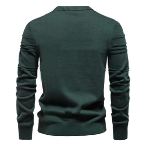 Detail view of dark green knit sweater featuring ribbed cuffs and textured sleeve folds