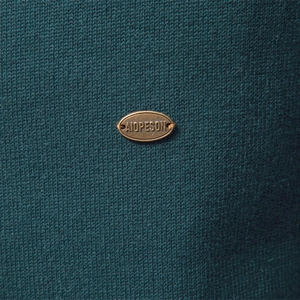 Men's dark teal knitted cardigan with textured fabric and metallic brand emblem detail