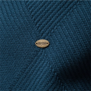 Men's dark lake blue knitted cardigan with textured weave and vintage bronze logo plaque
