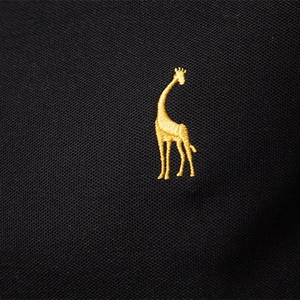 Close-up of black pique knit polo shirt featuring a gold embroidered giraffe logo