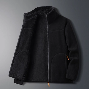 Macro detail of black reversible polar fleece jacket with bright orange zipper puller