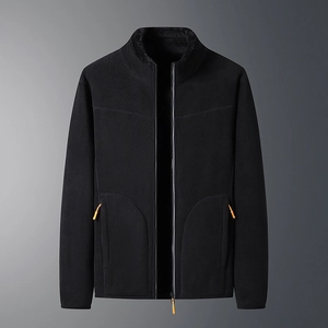 Detail of black fleece jacket featuring orange zipper pulls and warm plush lining