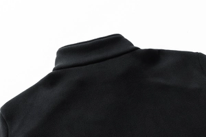 Dettaglio della giacca in pile nero che mostra il collo alto e le cuciture sulle spalle