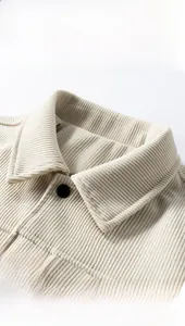 Detailed close-up of beige corduroy jacket collar with premium texture and black button